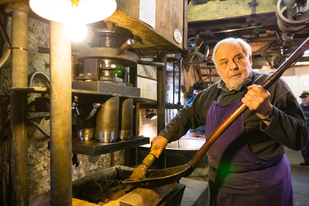 portrait du propriétaire du Moulin de la Veyssière, en train de fabriquer artisanalement de l'huile de noix